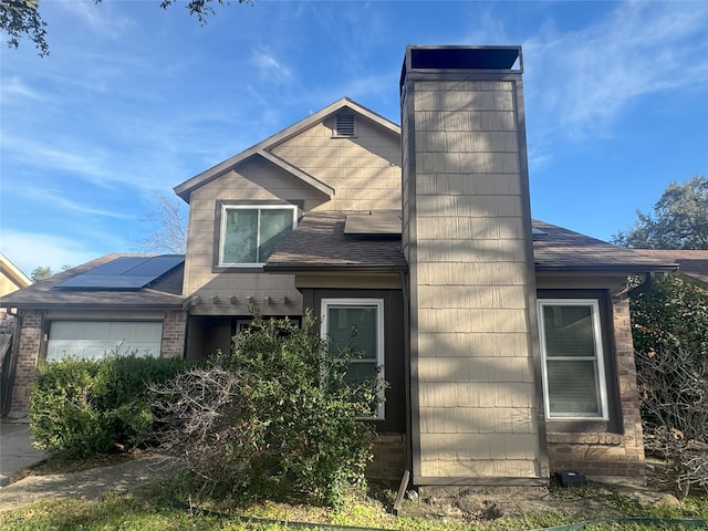 view of front of home with a garage and solar panels