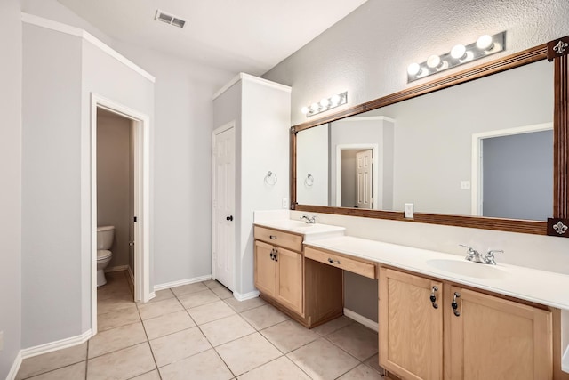 bathroom with vanity, toilet, and tile patterned floors