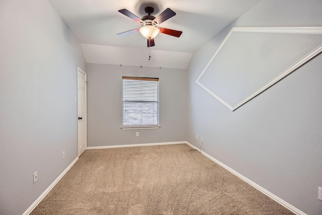 carpeted empty room with vaulted ceiling and ceiling fan