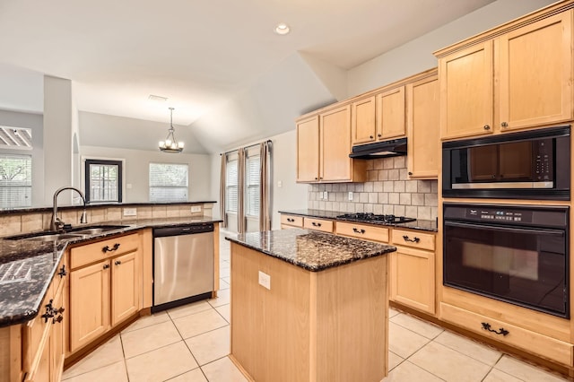 kitchen featuring a center island, decorative light fixtures, black appliances, sink, and dark stone counters