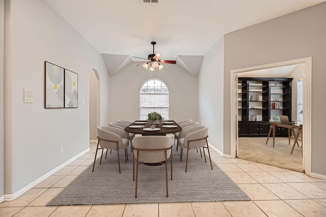 tiled dining room with lofted ceiling and ceiling fan