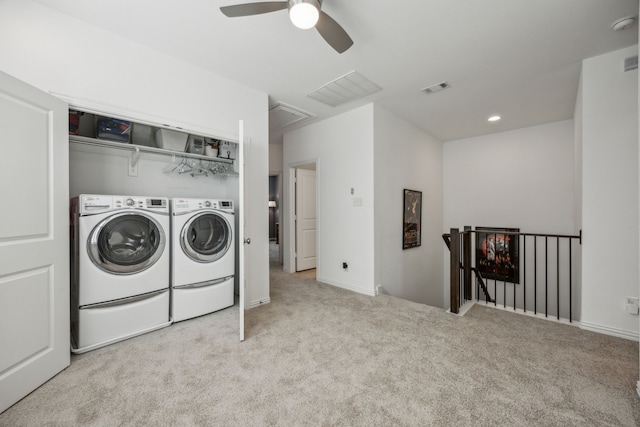 laundry area featuring ceiling fan, light colored carpet, and washer and clothes dryer