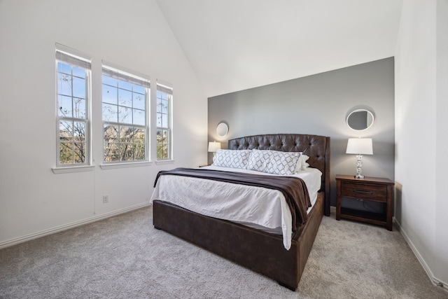 bedroom featuring light colored carpet and high vaulted ceiling