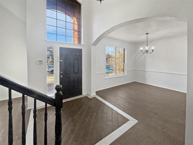 entryway with dark hardwood / wood-style floors and a chandelier