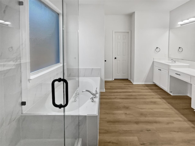 bathroom featuring vanity, wood-type flooring, and shower with separate bathtub