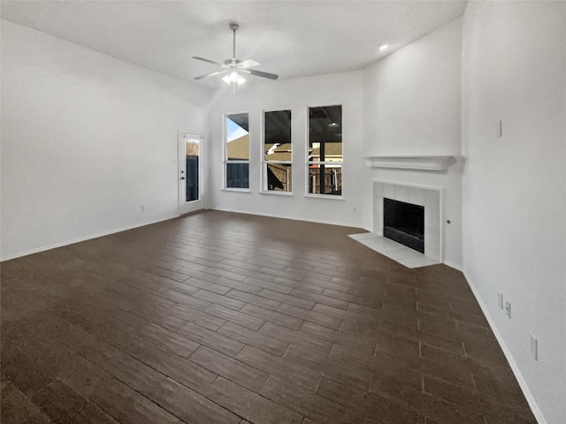 unfurnished living room featuring ceiling fan and a tiled fireplace