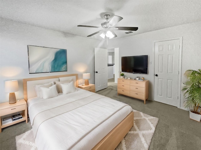 carpeted bedroom featuring a textured ceiling and ceiling fan