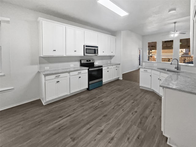 kitchen featuring sink, dark wood-type flooring, ceiling fan, appliances with stainless steel finishes, and white cabinetry