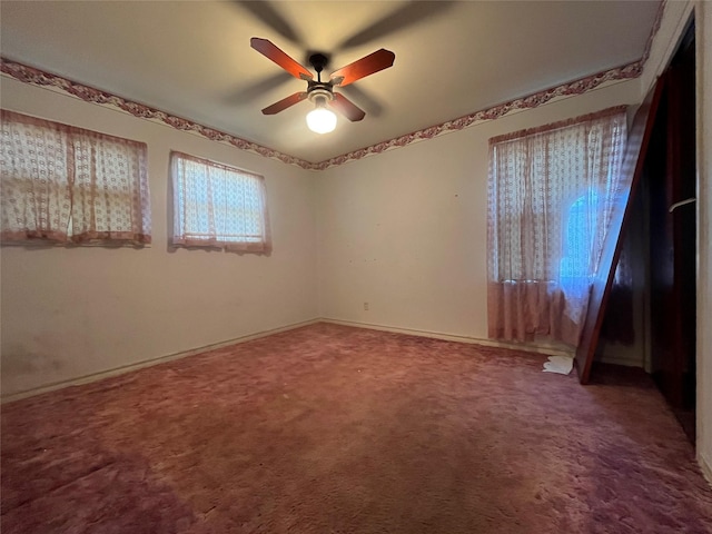 unfurnished room with ceiling fan and carpet flooring