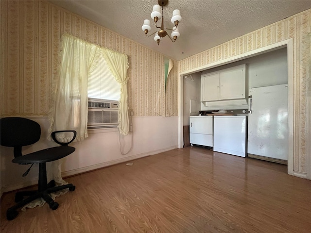 interior space with wood-type flooring, separate washer and dryer, a textured ceiling, and a chandelier