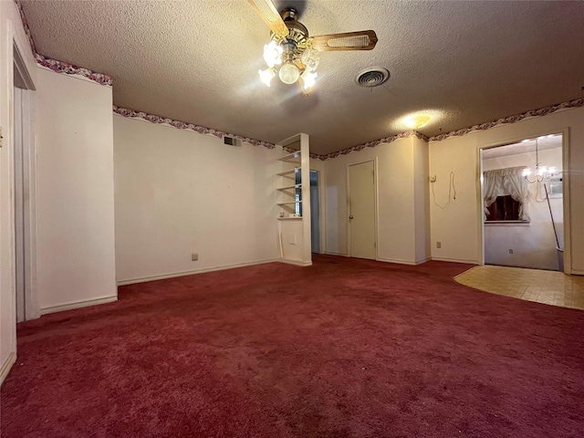 spare room featuring ceiling fan with notable chandelier, carpet floors, and a textured ceiling