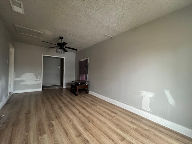 interior space with ceiling fan, light wood-type flooring, and a textured ceiling