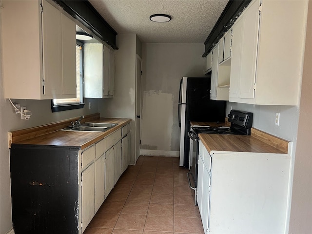 kitchen featuring sink, white cabinetry, range with electric stovetop, a textured ceiling, and light tile patterned flooring