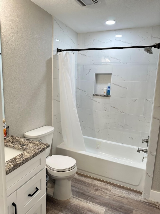 full bathroom featuring toilet, shower / tub combo, a textured ceiling, vanity, and hardwood / wood-style floors