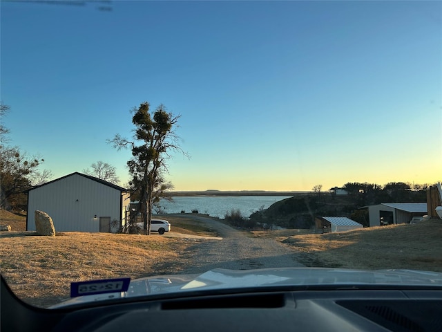 view of front facade featuring a water view and an outbuilding