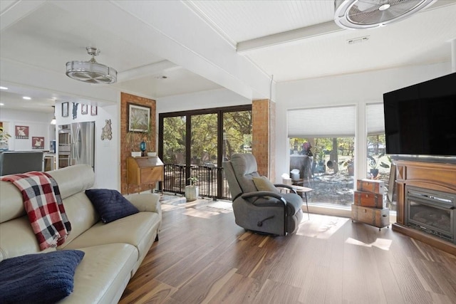 living room featuring a healthy amount of sunlight, hardwood / wood-style floors, and beamed ceiling