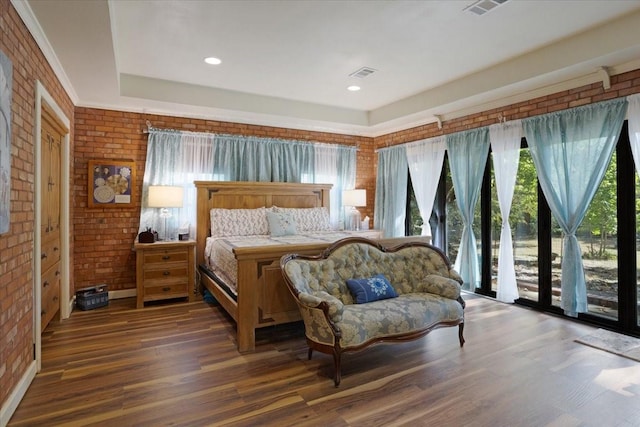 bedroom with access to outside, dark hardwood / wood-style floors, and brick wall