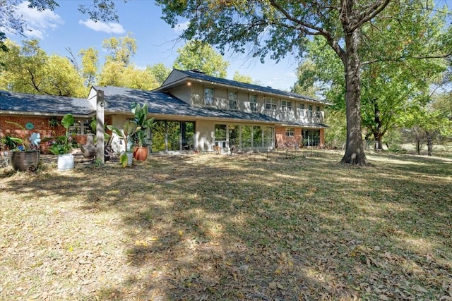 rear view of property with a lawn