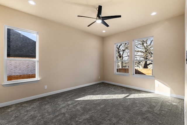 spare room featuring ceiling fan and dark carpet