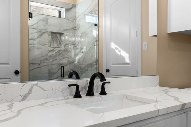 bathroom with a shower with door and vanity