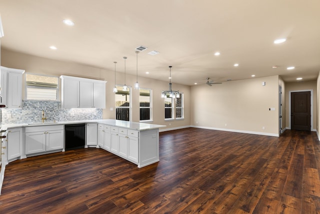 kitchen with backsplash, black dishwasher, dark hardwood / wood-style floors, and white cabinets