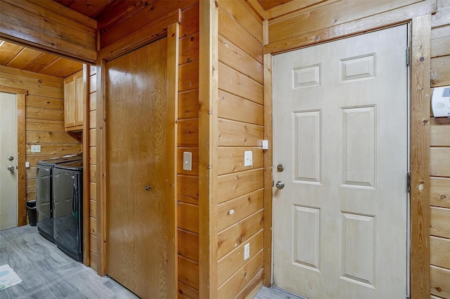 interior space with separate washer and dryer, wooden walls, and wooden ceiling