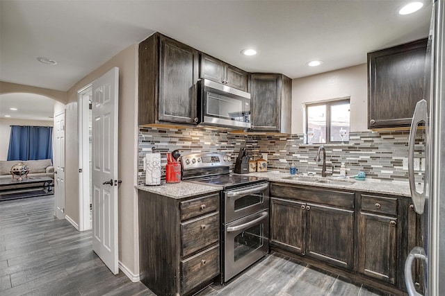 kitchen featuring sink, decorative backsplash, dark brown cabinets, and stainless steel appliances