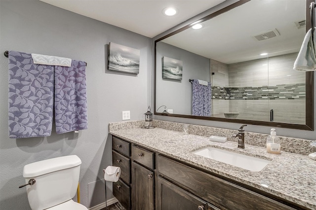 bathroom with vanity, toilet, and a shower with shower door