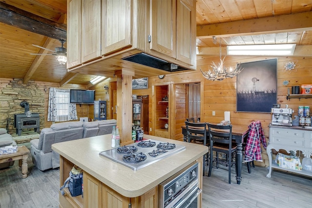 kitchen with wood walls, vaulted ceiling with beams, gas cooktop, wood ceiling, and light brown cabinets