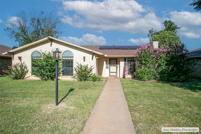 ranch-style house with a front lawn and solar panels