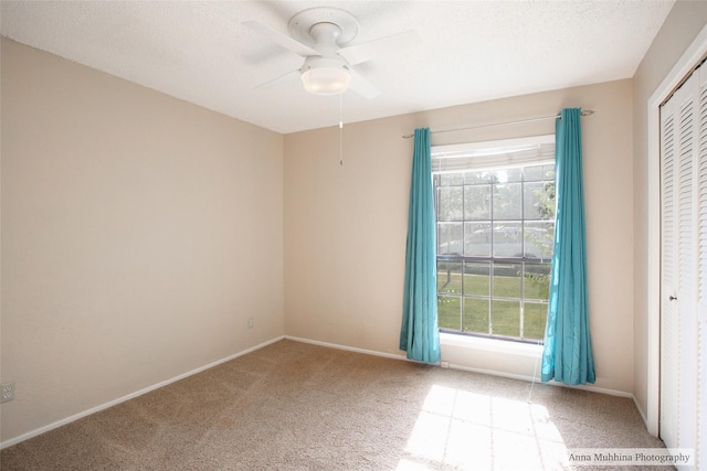 spare room featuring ceiling fan and carpet