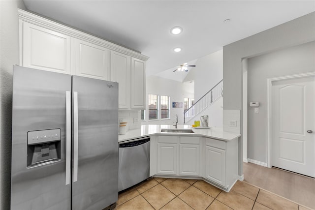 kitchen with sink, light tile patterned floors, stainless steel appliances, and white cabinets