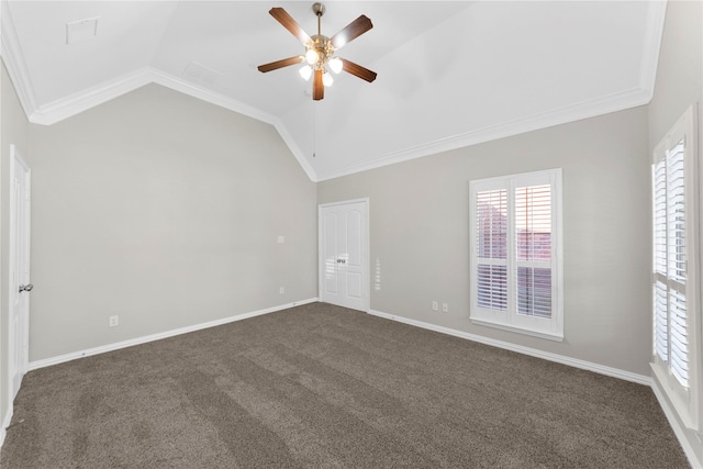 empty room with ornamental molding, lofted ceiling, and dark colored carpet