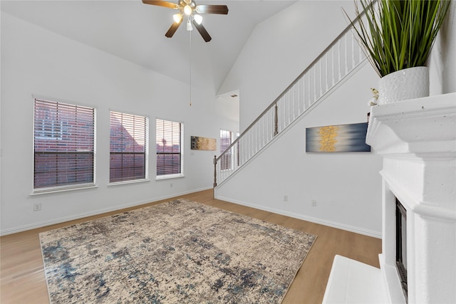 living room with ceiling fan, high vaulted ceiling, and light hardwood / wood-style floors