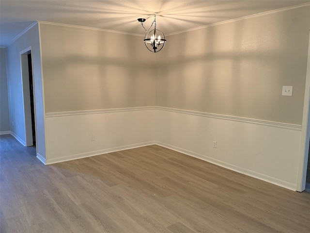 empty room with wood-type flooring and a notable chandelier