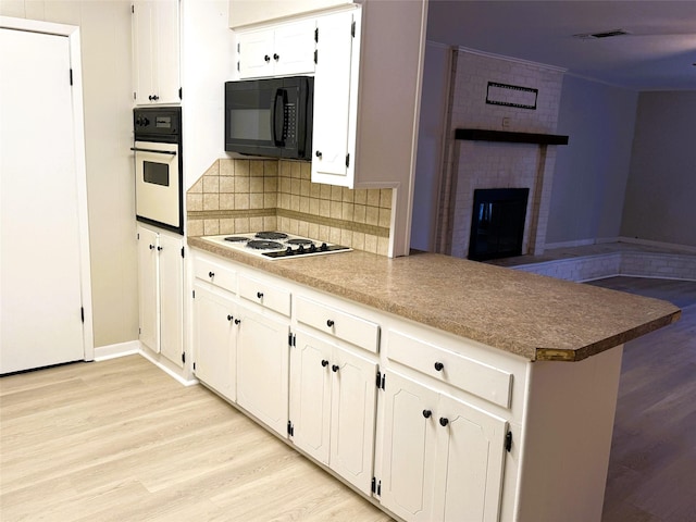 kitchen featuring white cabinetry, white appliances, tasteful backsplash, and kitchen peninsula