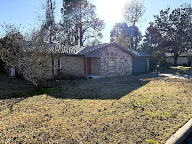 view of front of home featuring central AC unit, a garage, and a front lawn