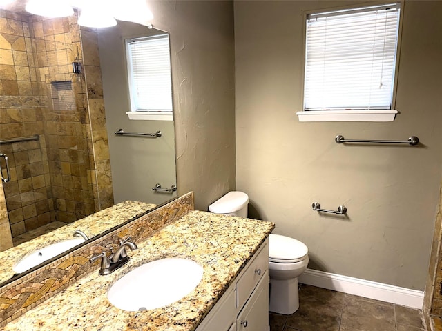 bathroom with vanity, tile patterned floors, toilet, and walk in shower