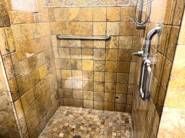 interior details with a tile shower