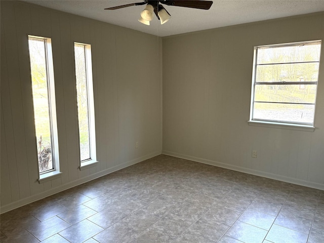 spare room with a textured ceiling and ceiling fan