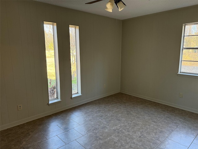 empty room with ceiling fan and a healthy amount of sunlight