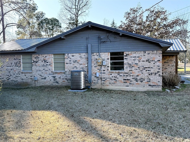 view of home's exterior with central AC and a lawn