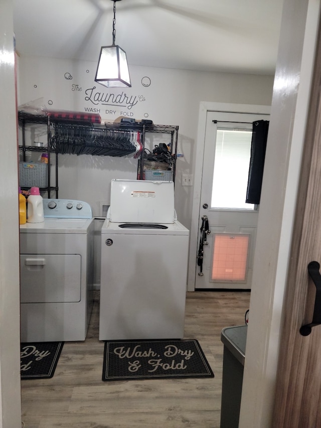 clothes washing area featuring hardwood / wood-style flooring and washing machine and dryer