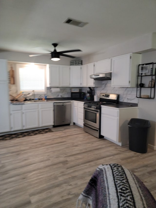 kitchen with tasteful backsplash, white cabinetry, ceiling fan, stainless steel appliances, and light hardwood / wood-style flooring