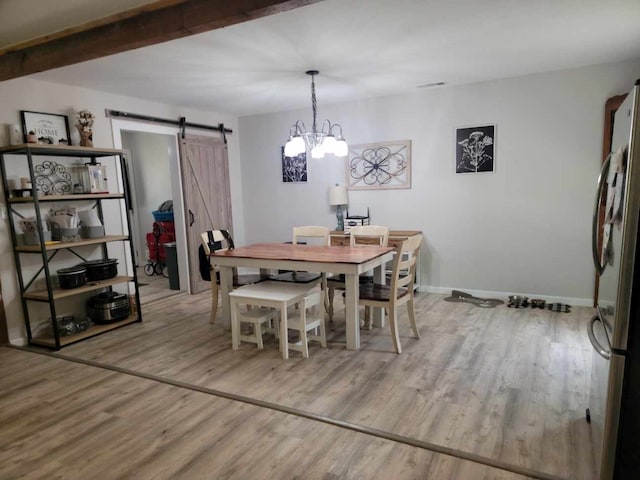 dining area with a barn door and light wood-type flooring