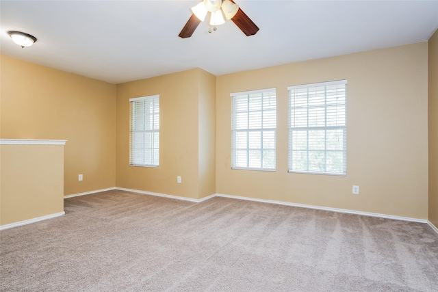 carpeted spare room with ceiling fan