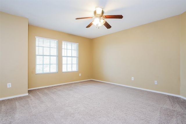 carpeted spare room featuring ceiling fan