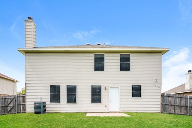 rear view of house with a yard and central air condition unit