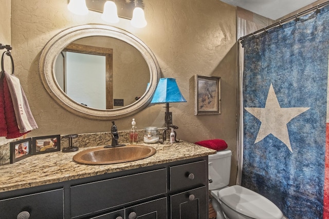 bathroom with vanity, a shower with shower curtain, and toilet