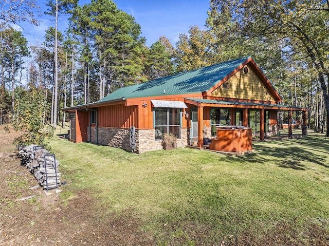 exterior space featuring a yard and a hot tub